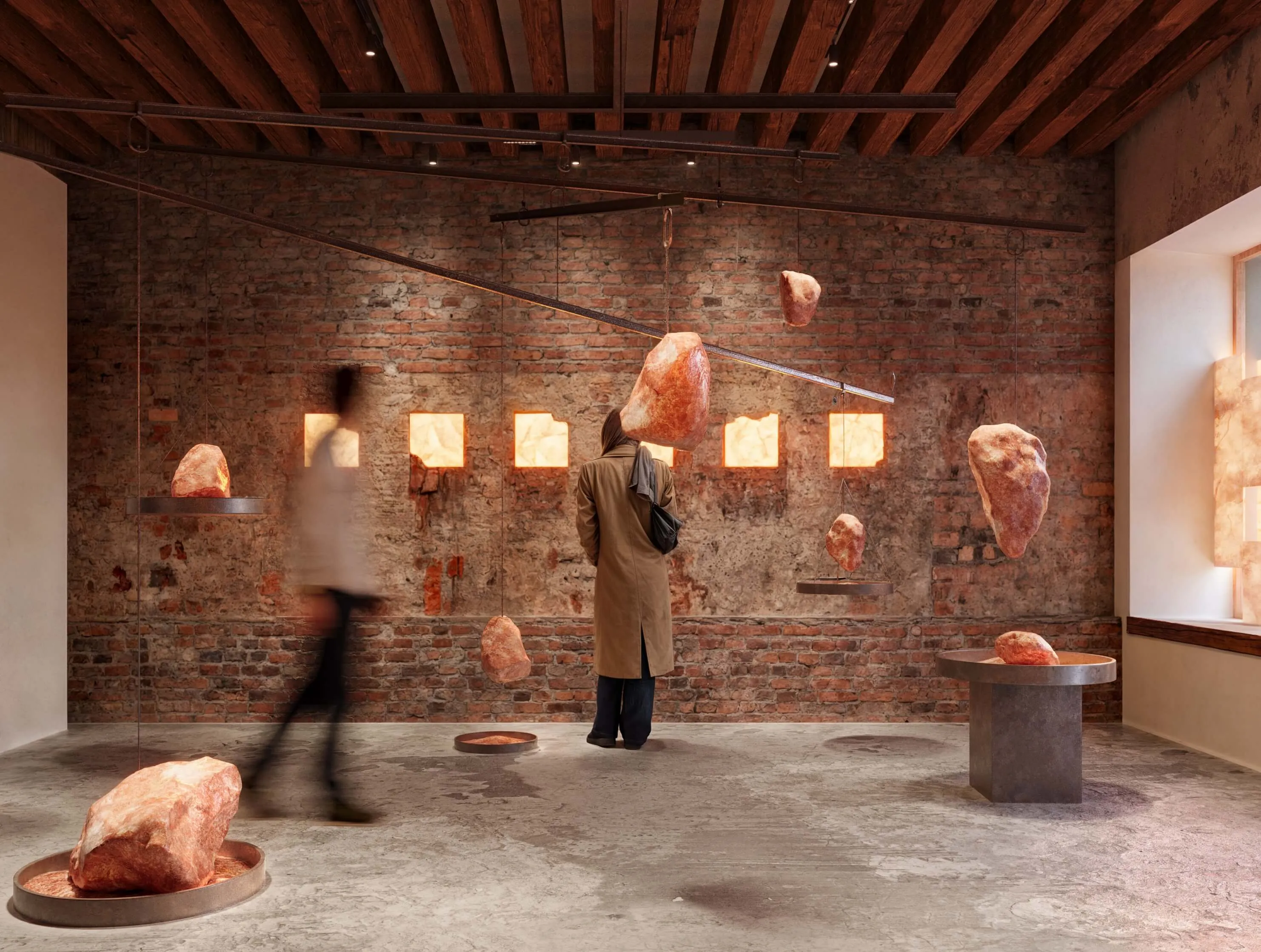 Interior of the (Fr)Agile Systems pavilion, with suspended rock salt formations in a brick-walled exhibition space